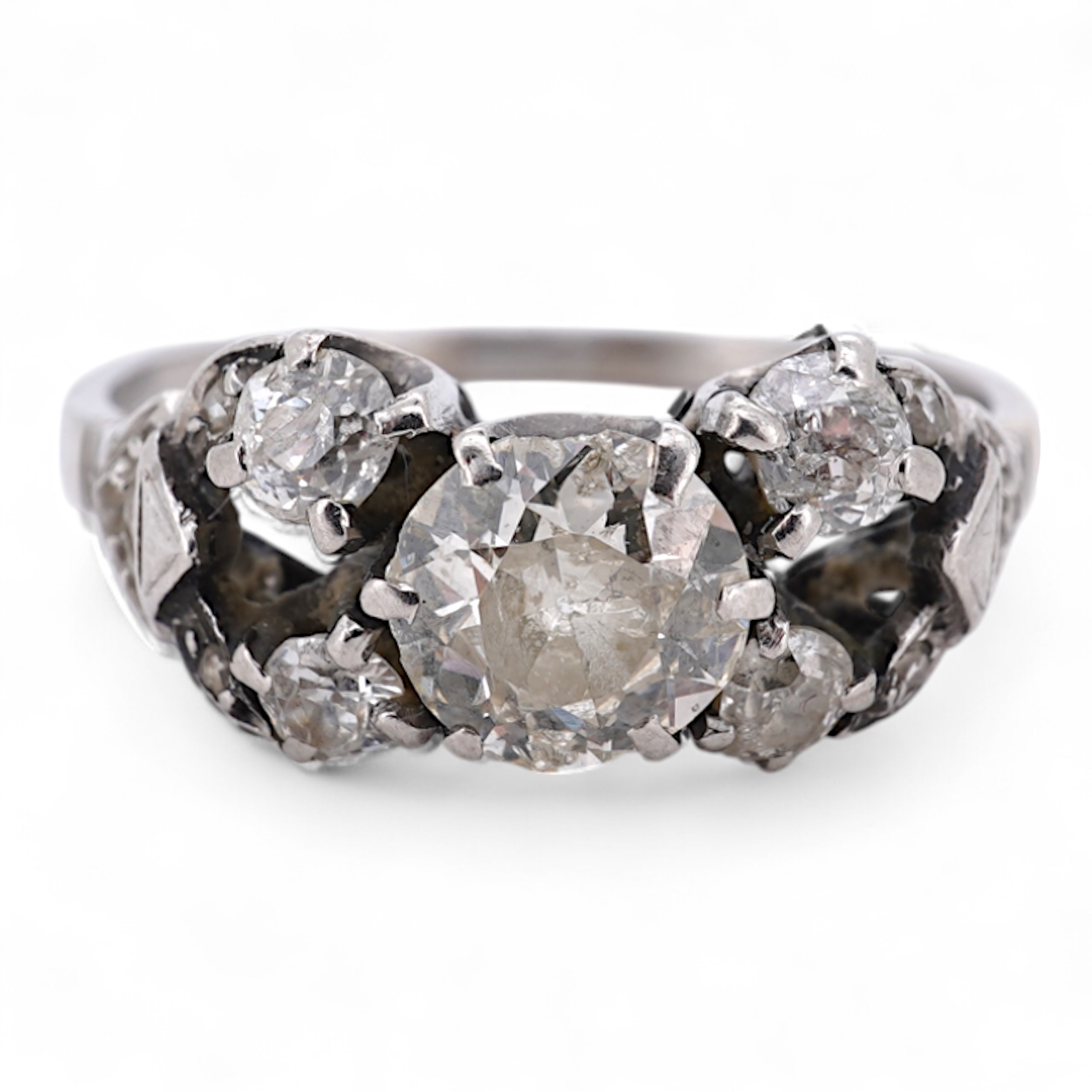 A white metal (stamped platin) and single stone diamond ring, flanked by four smaller diamonds and rose cut diamond chip set shoulders, size P, gross weight 3.8 grams.
